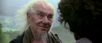 Movie still from “Dragonslayer” (1981), directed by Matthew Robbins – An old man with long white hair and a white beard; Close Up shot, Over the shoulder angle