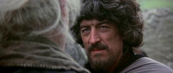 Movie still from “Dragonslayer” (1981), directed by Matthew Robbins – A person with a beard; Close Up shot, Over the shoulder angle