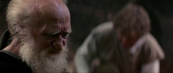 Movie still from “Dragonslayer” (1981), directed by Matthew Robbins – An old man with a long white beard; Close Up shot, Over the shoulder angle