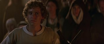 Movie still from “Dragonslayer” (1981), directed by Matthew Robbins – A man in a tan shirt is in a crowd; Close Up shot, Over the shoulder angle