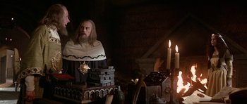 Movie still from “Dragonslayer” (1981), directed by Matthew Robbins – A man in a robe and a cape in front of candles; Medium shot, Over the shoulder angle