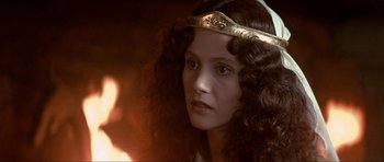 Movie still from “Dragonslayer” (1981), directed by Matthew Robbins – A woman with long curly hair wearing a gold crown; Close Up shot, Over the shoulder angle