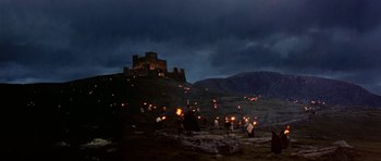 Movie still from “Dragonslayer” (1981), directed by Matthew Robbins – A group of people standing on top of a hill; Extreme Wide shot, Low angle
