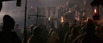 Movie still from “Dragonslayer” (1981), directed by Matthew Robbins – A crowd of people standing in front of a building; Wide shot, Low angle