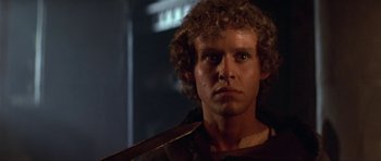Movie still from “Dragonslayer” (1981), directed by Matthew Robbins – A person with curly brown hair; Close Up shot, Over the shoulder angle