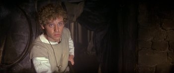 Movie still from “Dragonslayer” (1981), directed by Matthew Robbins – A man in a white shirt is pointing at the camera; Close Up shot, Low angle