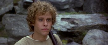 Movie still from “Dragonslayer” (1981), directed by Matthew Robbins – A man with a curly hair holding a bag; Close Up shot, Low angle