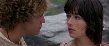 Movie still from “Dragonslayer” (1981), directed by Matthew Robbins – A man and a woman looking at each other in front of some rocks; Close Up shot, Over the shoulder angle
