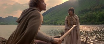 Movie still from “Dragonslayer” (1981), directed by Matthew Robbins – A man and a woman are in a boat on the water; Medium shot, Low angle