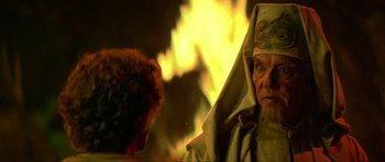 Movie still from “Dragonslayer” (1981), directed by Matthew Robbins – An old man wearing a robe and a hood; Close Up shot, Over the shoulder angle