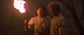 Movie still from “Dragonslayer” (1981), directed by Matthew Robbins – A woman and a young man holding a torch; Medium shot, Low angle