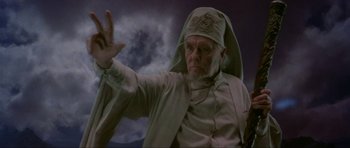 Movie still from “Dragonslayer” (1981), directed by Matthew Robbins – An old man with a white beard and a white hat; Medium shot, Low angle