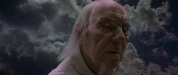 Movie still from “Dragonslayer” (1981), directed by Matthew Robbins – An old man with white hair and a white beard; Close Up shot, Low angle