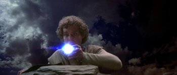 Movie still from “Dragonslayer” (1981), directed by Matthew Robbins – A man holding a light up flashlight in his hand; Medium shot, Overhead angle