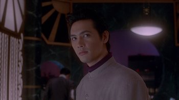 A man in a white shirt is looking at the camera