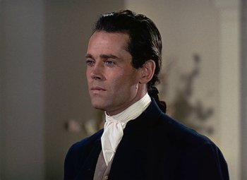 Movie still from “Drums Along the Mohawk” (1939), directed by John Ford – A person wearing a suit and tie; Close Up shot, Over the shoulder angle