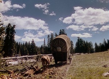 Movie still from “Drums Along the Mohawk” (1939), directed by John Ford – A covered wagon is parked in the middle of a field; Extreme Wide shot, Low angle