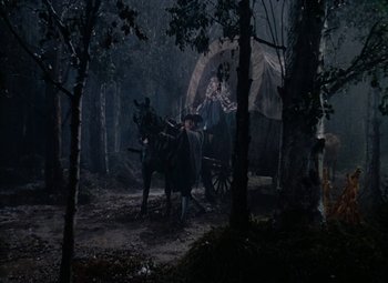 Movie still from “Drums Along the Mohawk” (1939), directed by John Ford – A horse drawn carriage in the middle of a forest; Wide shot, Low angle