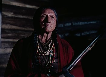Movie still from “Drums Along the Mohawk” (1939), directed by John Ford – An old woman in a red robe holding a rifle; Close Up shot, Low angle