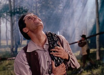 Movie still from “Drums Along the Mohawk” (1939), directed by John Ford – A man holding a chain in his hands; Close Up shot, Low angle