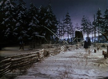 Movie still from “Drums Along the Mohawk” (1939), directed by John Ford – A man standing in the snow next to a wooden fence; Extreme Wide shot, Low angle