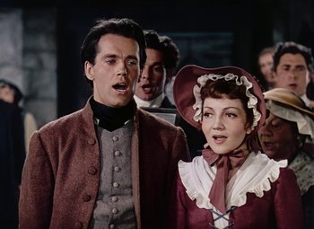 Movie still from “Drums Along the Mohawk” (1939), directed by John Ford – A man and a woman sing in front of other people; Medium shot, Low angle