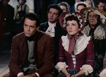 Movie still from “Drums Along the Mohawk” (1939), directed by John Ford – A group of people sitting in a room together; Medium shot, High angle