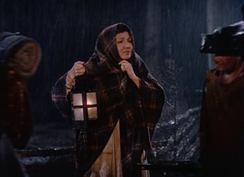 Movie still from “Drums Along the Mohawk” (1939), directed by John Ford – A woman wrapped in a blanket holding a lantern; Medium shot, Low angle