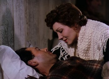 Movie still from “Drums Along the Mohawk” (1939), directed by John Ford – A man and a woman laying in a bed together; Close Up shot, Overhead angle