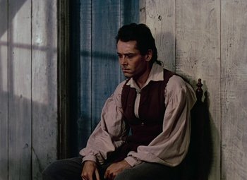 Movie still from “Drums Along the Mohawk” (1939), directed by John Ford – A man sitting on a chair in front of a window; Medium shot, Over the shoulder angle