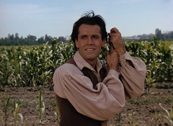 Movie still from “Drums Along the Mohawk” (1939), directed by John Ford – A man standing in front of a field of corn; Close Up shot, Low angle