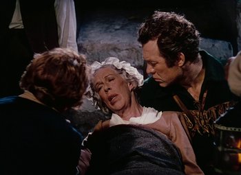 Movie still from “Drums Along the Mohawk” (1939), directed by John Ford – A man and a woman standing next to an old woman; Medium shot, High angle