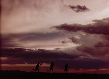 Movie still from “Drums Along the Mohawk” (1939), directed by John Ford – A group of people running on a field at sunset; Extreme Wide shot, Low angle
