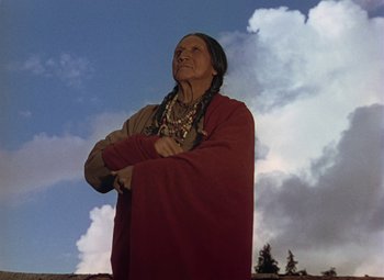 Movie still from “Drums Along the Mohawk” (1939), directed by John Ford – An old native american standing in front of a cloud filled sky; Medium shot, Low angle