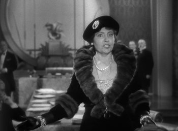 Movie still from “Duck Soup” (1933), directed by Leo McCarey – An old photo of a woman wearing a fur coat; Medium shot, Over the shoulder angle