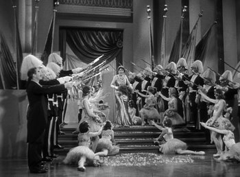 Movie still from “Duck Soup” (1933), directed by Leo McCarey – A black and white photo of a group of men and women in costumes; Extreme Wide shot, High angle