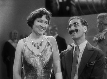 Movie still from “Duck Soup” (1933), directed by Leo McCarey – An old photo of a man and a woman holding hands; Medium shot, Low angle