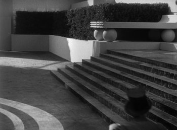 Movie still from “Duck Soup” (1933), directed by Leo McCarey – A black and white photo of a person walking down a set of stairs; Extreme Wide shot, High angle