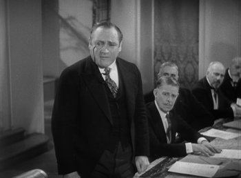Movie still from “Duck Soup” (1933), directed by Leo McCarey – An old photo of a man standing in front of other men; Medium shot, Low angle