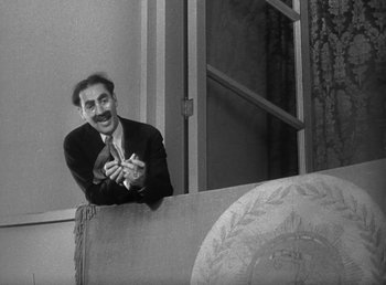 Movie still from “Duck Soup” (1933), directed by Leo McCarey – An old photo of a man leaning on a wall; Medium shot, Low angle