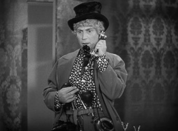 Movie still from “Duck Soup” (1933), directed by Leo McCarey – An older man wearing a top hat talking on a phone; Medium shot, High angle