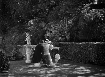 Movie still from “Duck Soup” (1933), directed by Leo McCarey – A man and a woman dressed in period clothing in a garden; Extreme Wide shot, High angle
