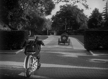 Movie still from “Duck Soup” (1933), directed by Leo McCarey – A black and white photo of a motorcycle on the street; Wide shot, High angle