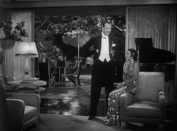 Movie still from “Duck Soup” (1933), directed by Leo McCarey – A man and a woman in formal wear in a living room; Wide shot, High angle