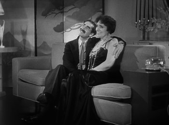 Movie still from “Duck Soup” (1933), directed by Leo McCarey – An older man and woman sitting next to each other on a couch; Medium shot, High angle