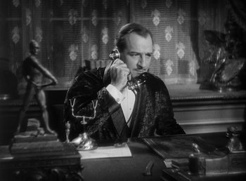 Movie still from “Duck Soup” (1933), directed by Leo McCarey – A man sitting at a table talking on a phone; Medium shot, High angle