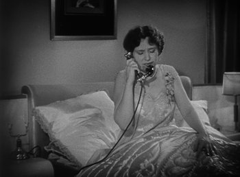 Movie still from “Duck Soup” (1933), directed by Leo McCarey – A woman sitting on a bed talking on a phone; Medium shot, High angle
