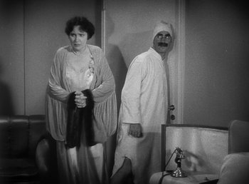Movie still from “Duck Soup” (1933), directed by Leo McCarey – An old photo of a man and a woman; Medium shot, High angle