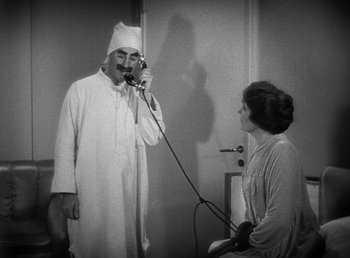 Movie still from “Duck Soup” (1933), directed by Leo McCarey – An old man in a white robe talking to a woman; Medium shot, High angle