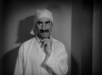 Movie still from “Duck Soup” (1933), directed by Leo McCarey – A man with a fake mustache wearing a hat and glasses; Close Up shot, High angle